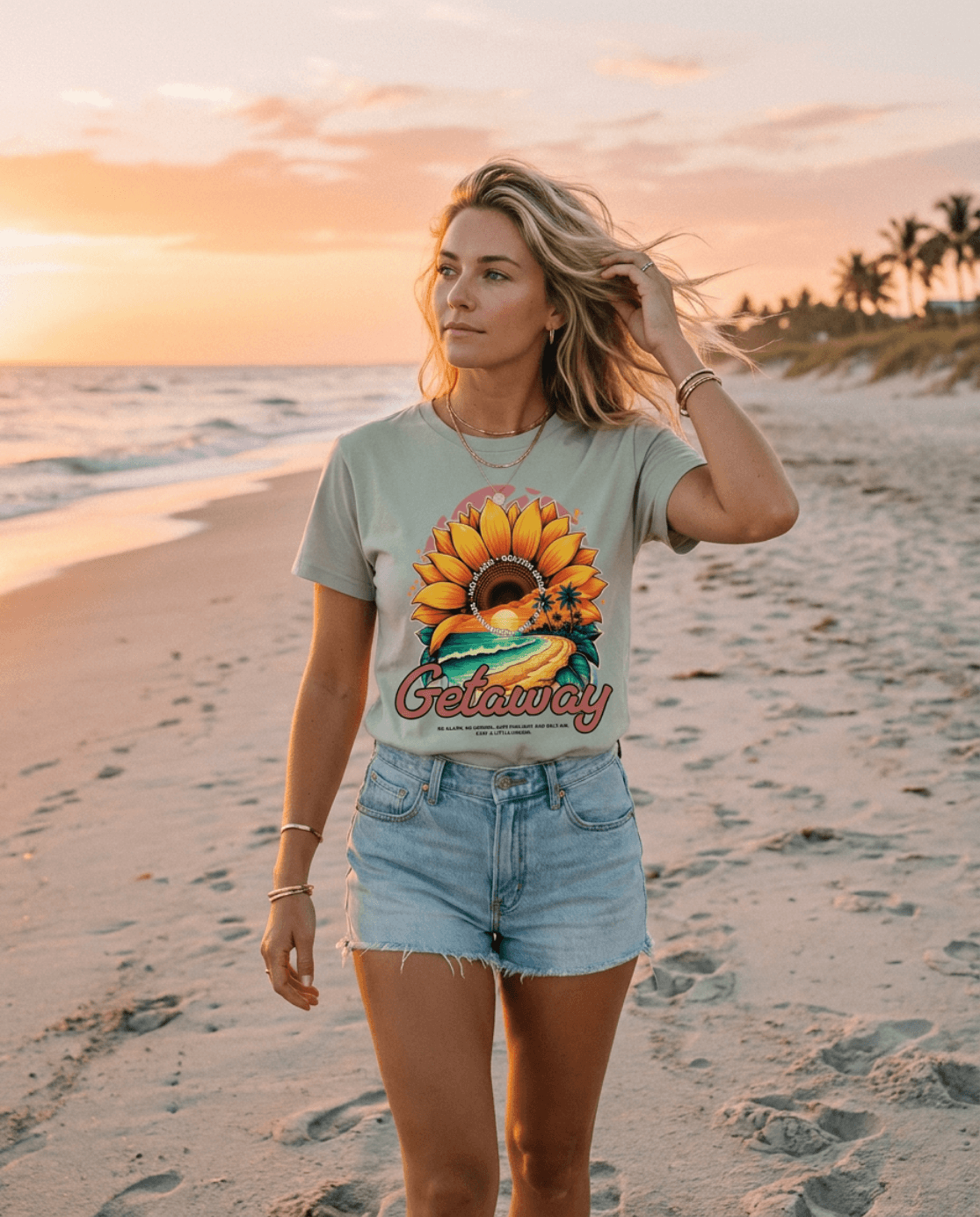 Woman wearing Getaway Sunflower Beach Tee – Bay walking on a sunset beach.