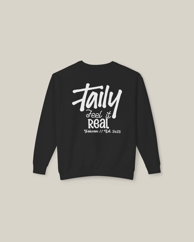 Black sweatshirt featuring bold 'Feel It Real' lettering and chest logo, perfect for streetwear style.