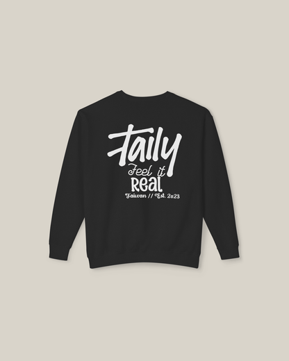 Black sweatshirt featuring bold 'Feel It Real' lettering and chest logo, perfect for streetwear style.