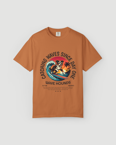 Wave Hounds Surf Tee – Yam featuring a vibrant retro surf graphic on a burnt orange tee.