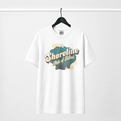 Shoreline State of Mind Tee – White featuring a vintage seashell graphic in deep teal and warm cream.