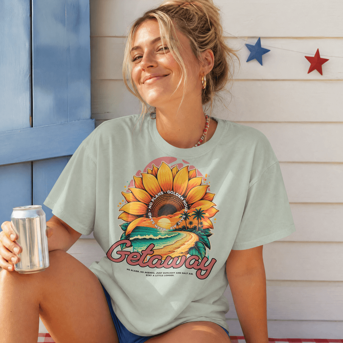 Model wearing Getaway Sunflower Beach Tee – Bay with sunflower graphic, enjoying the beach vibe.