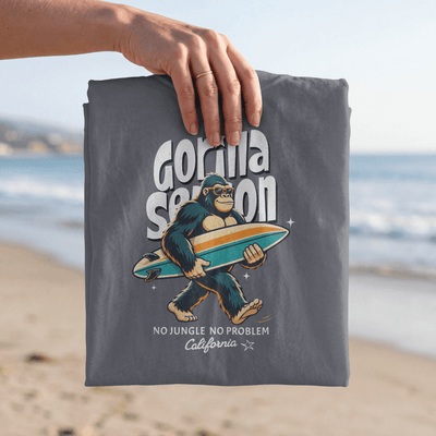 Gorilla Season Surf Tee – Navy showcasing a laid-back gorilla with a surfboard on the beach.