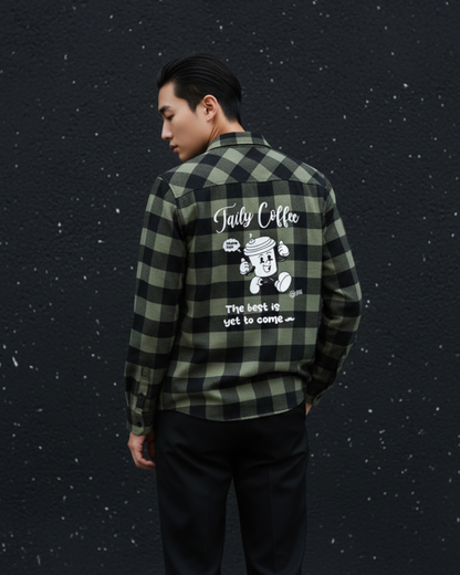 Model wearing Taily Coffee flannel shirt in Olive with playful graphic on the back against a dark background.