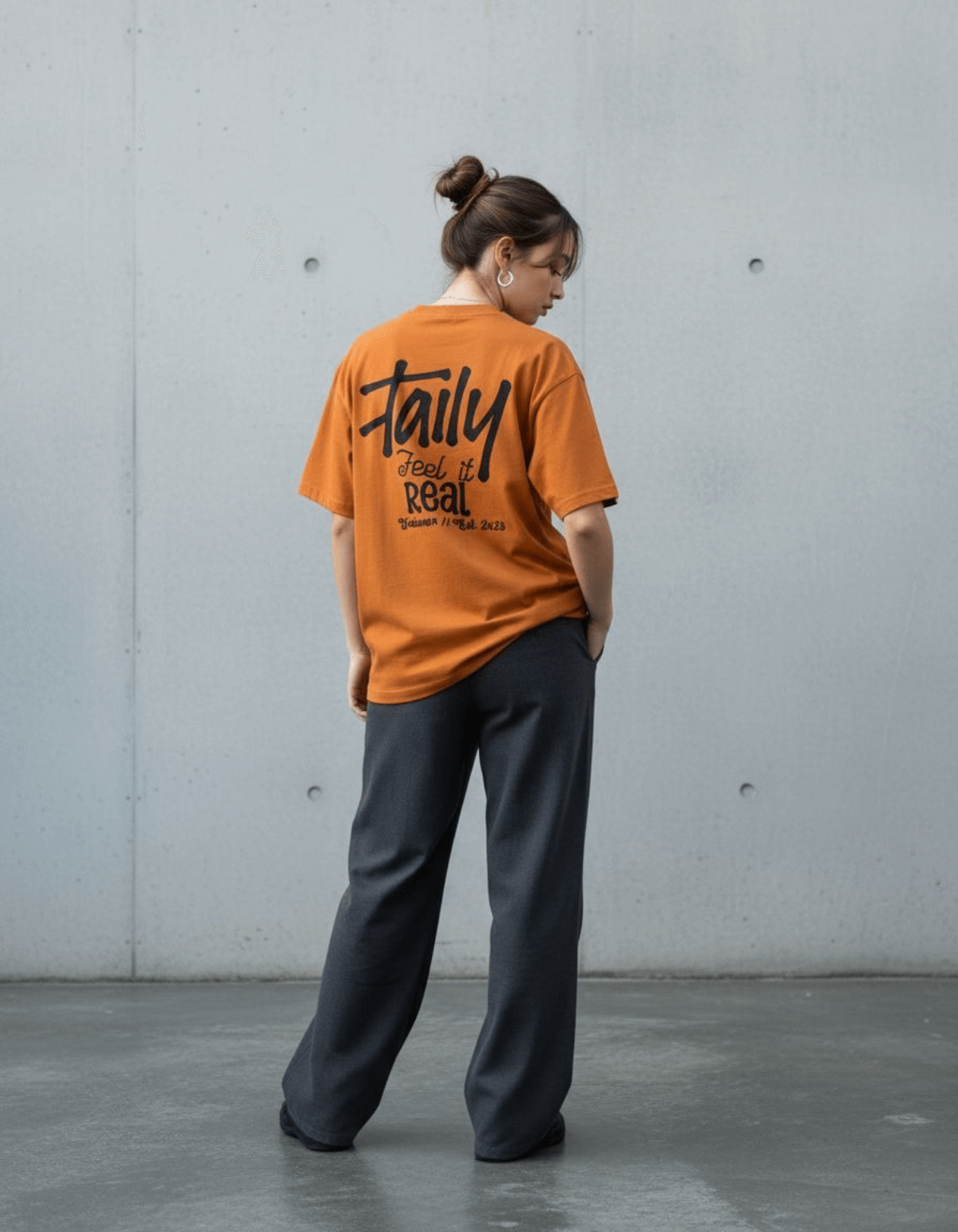 Woman wearing Taily Feel It Real Boxy Tee in toast, showcasing streetwear boxy t-shirt style and bold lettering.