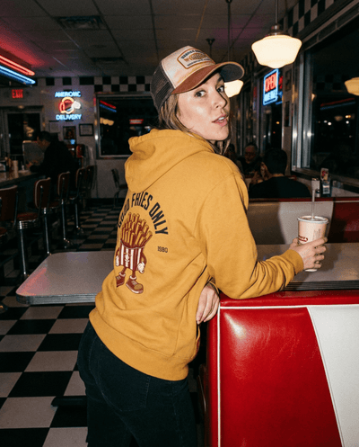 Good Fries Only Retro French Fries Hoodie – Mustard worn in a retro diner setting with a nostalgic vibe.