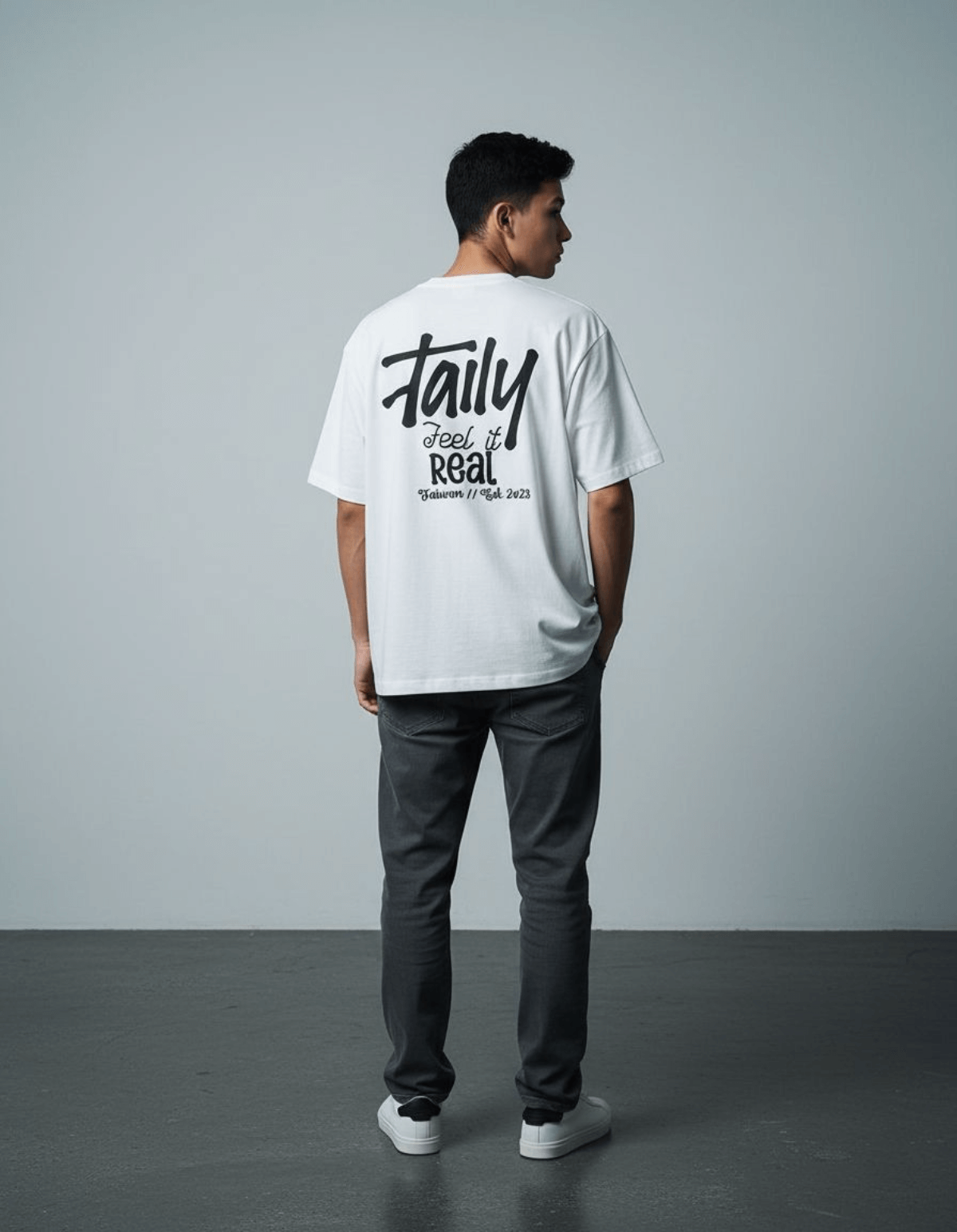 Model wearing Taily Feel It Real Boxy Tee – White, showcasing the back with the streetwear boxy t-shirt logo.