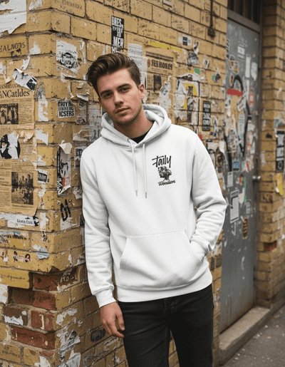 A young man wearing a Taily Wonders vintage graphic hoodie in white, standing against a textured wall covered with posters.