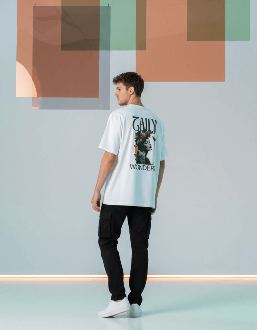 Model wearing Taily Wonders vintage boxy t-shirt in white featuring floral and butterfly designs on back.