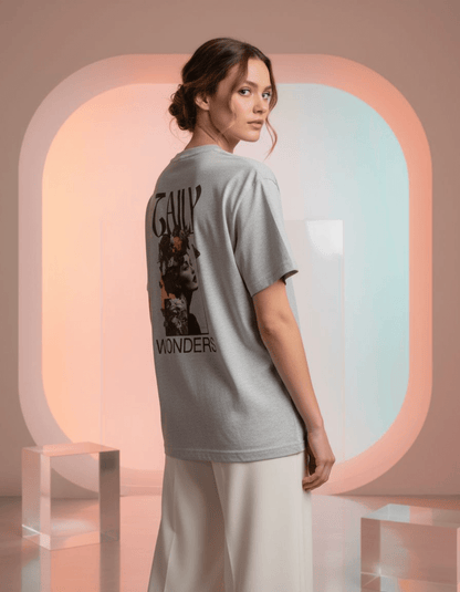 Model wearing Taily Wonders vintage boxy t-shirt in athletic gray, showcasing artistic back design.