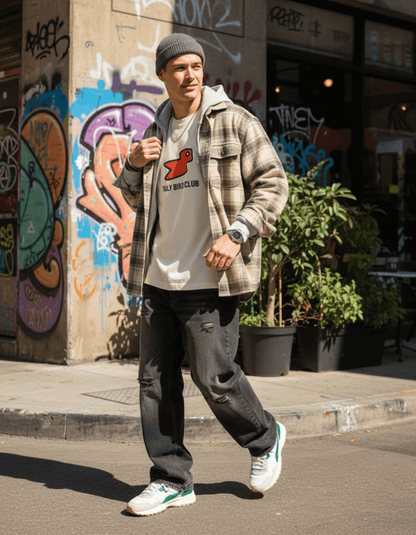 Style shot of a man wearing Taily Bird Club Streetwear Boxy T-Shirt with bird design in a urban setting.