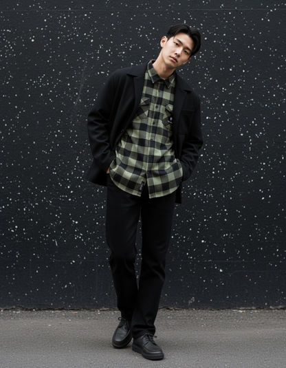 Model wearing Taily Coffee flannel shirt in Olive with black pants against a textured wall background.
