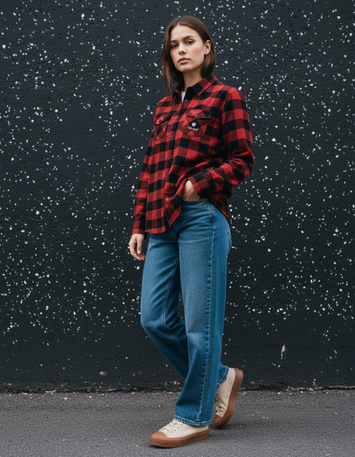 Model wearing Taily Coffee flannel shirt in Red with blue jeans, standing against a speckled black background.