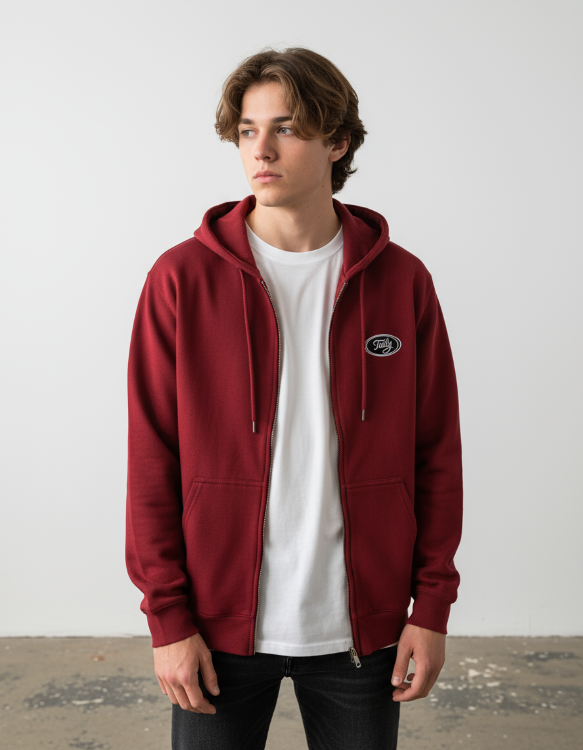 Taily Zip Hoodie in cardinal red, featuring an embroidered logo, worn by a model over a white shirt.