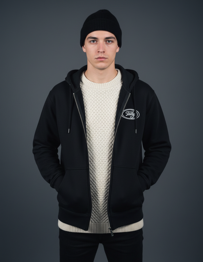 Model wearing Taily Zip Hoodie in black, styled with a knitted sweater and beanie, showcasing classic streetwear.