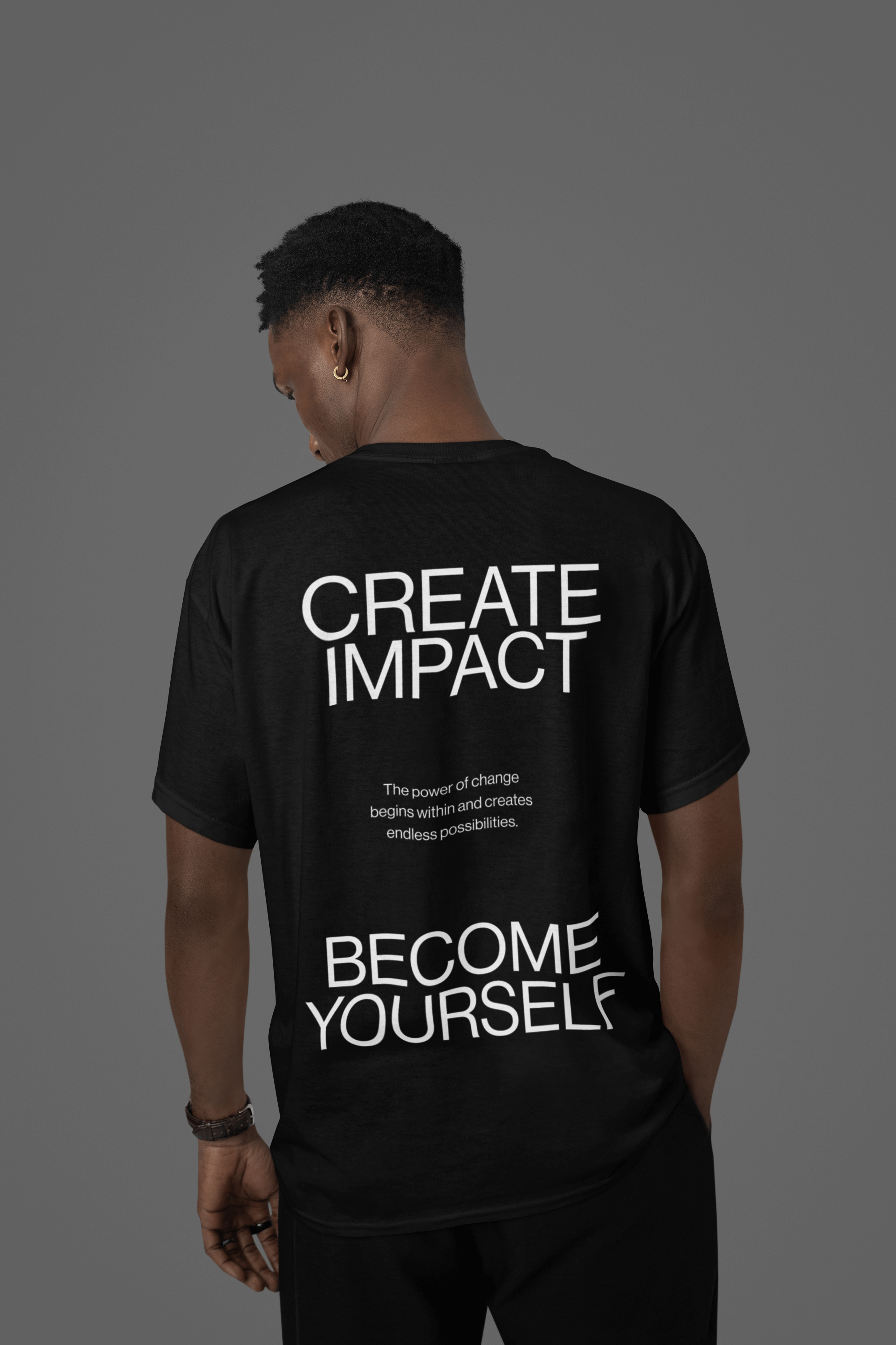 Black oversized tee with uplifting message 'Create Impact' and 'Become Yourself' on the back, showcasing personal transformation.