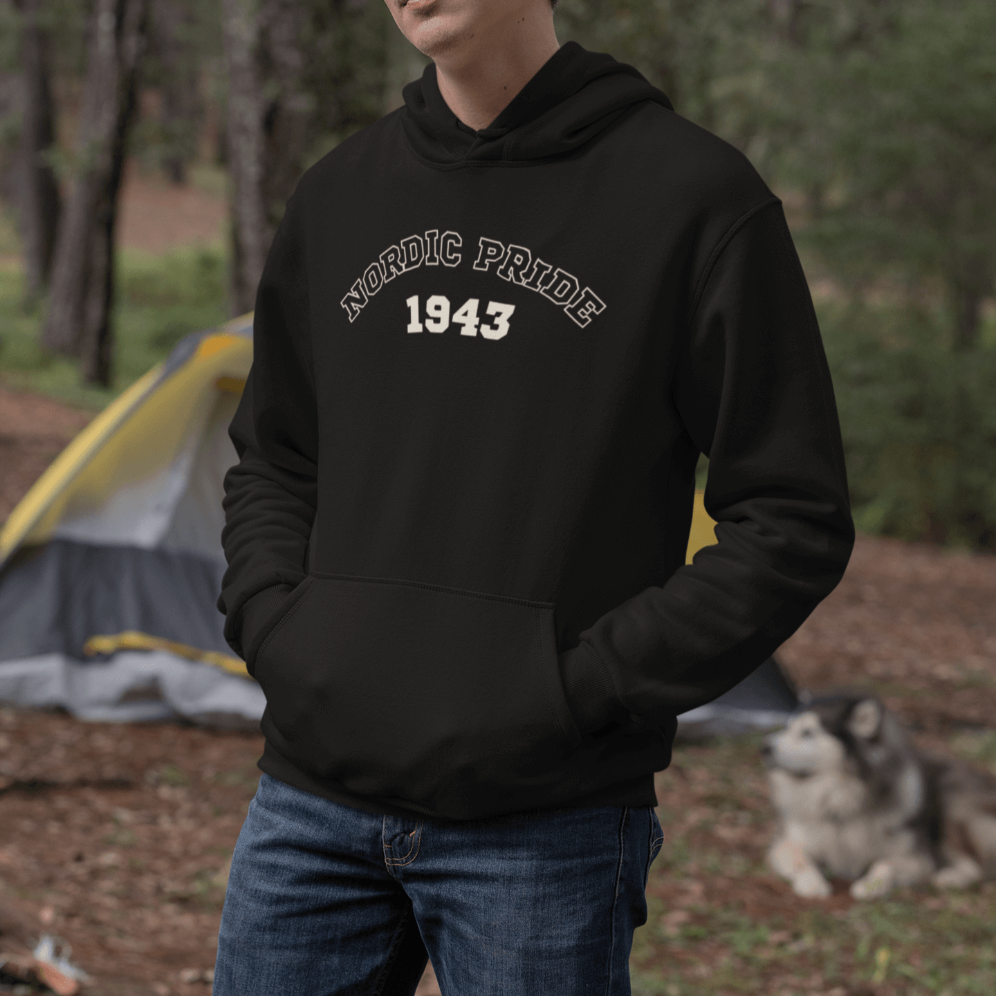 Person wearing a black hoodie featuring "NORDIC PRIDE 1943" design, with a dog in the background near a camping tent.