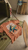 Gorilla Season Surf Tee – Yam displayed on a vintage truck, showcasing its bold surf graphic and burnt orange color.