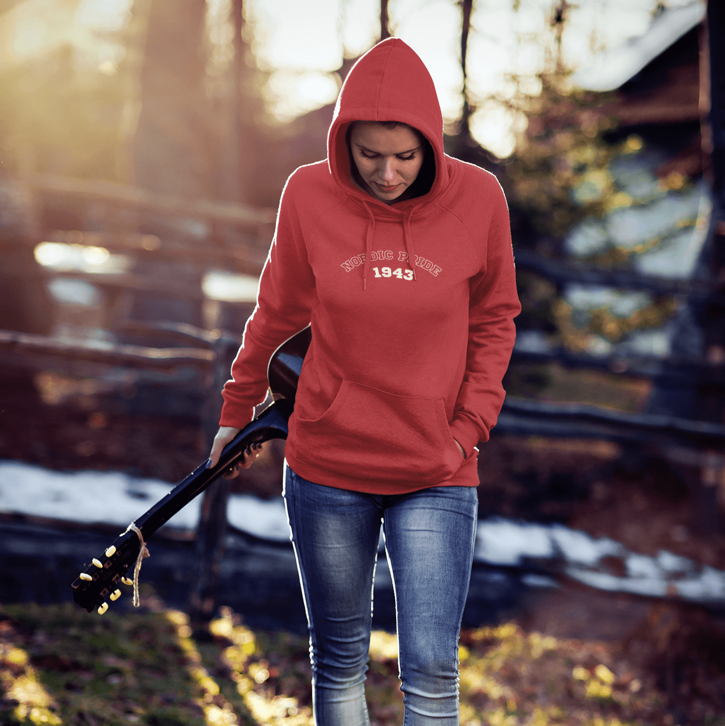 Woman wearing a relaxed fit Swedish Vallhund hoodie with "NORDIC PRIDE 1943" design, holding a guitar outdoors.