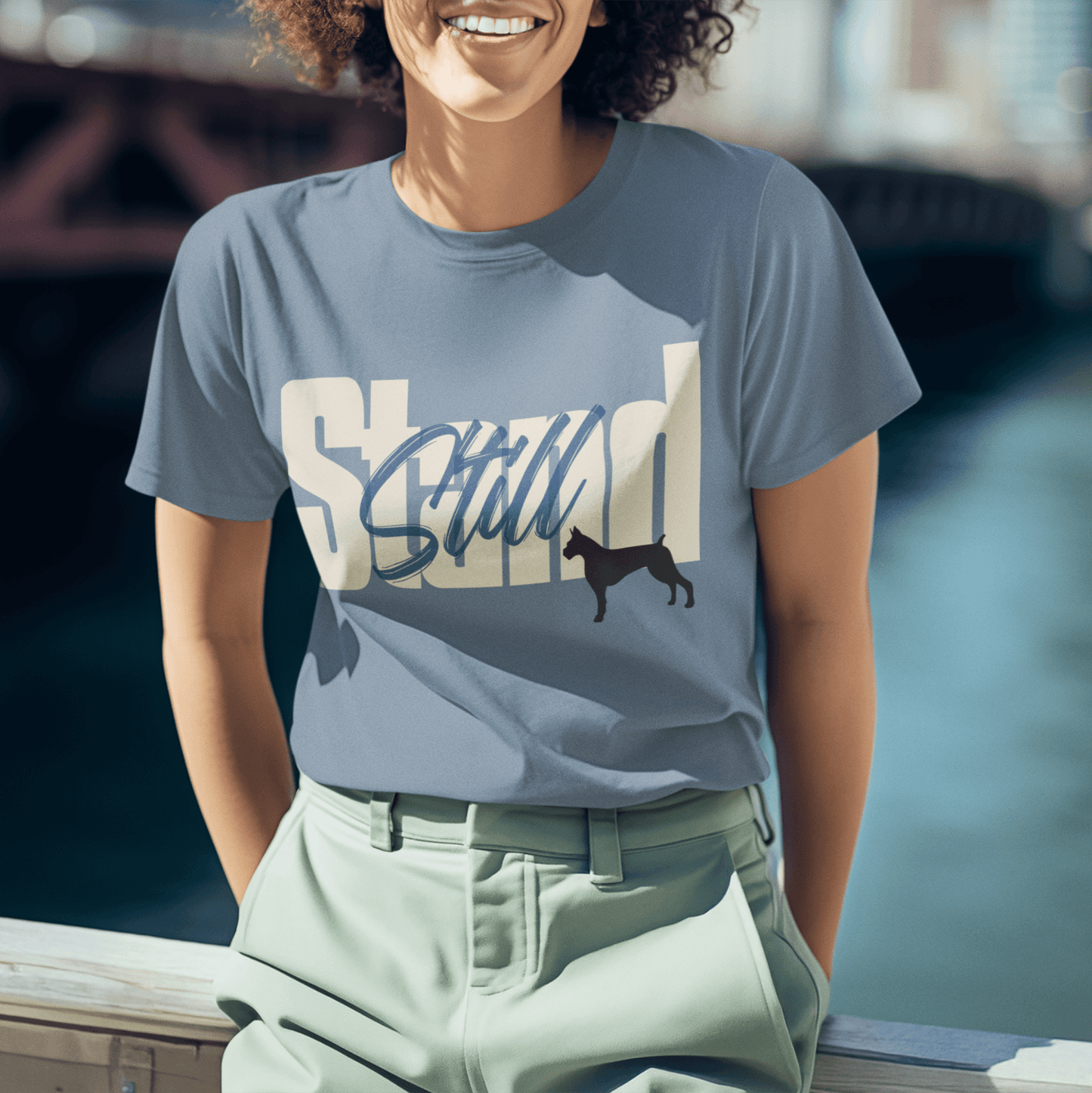 Stylish T-shirt featuring the bold 'Stand Still' typography in white and blue, complemented by a black dog silhouette. Perfect for city adventures and casual outings.