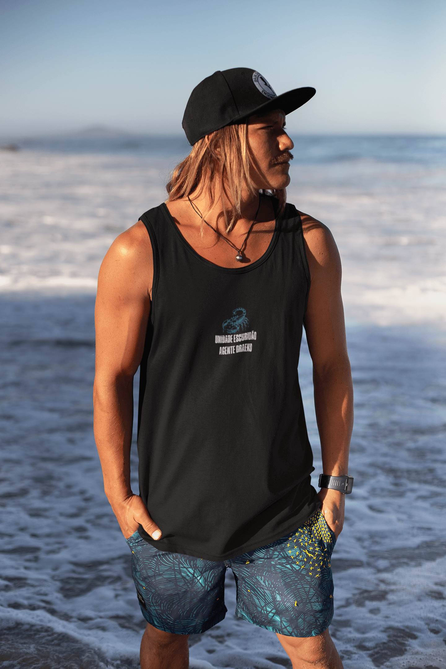 Model wearing DRAEKO Tank – Agent of the Shadows by the ocean, showcasing scorpion insignia and unique design.